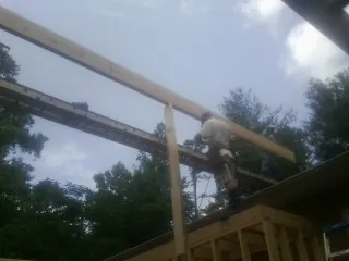 Carpenter setting a ridge beam over a new addition frame — Ice Dam Removal by Roofing Brothers in Verdon