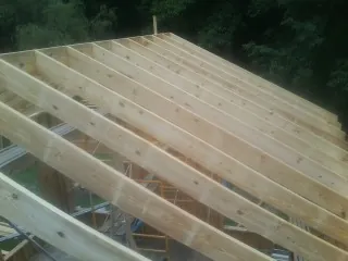 New roof rafters set over an addition before sheathing in Verdon