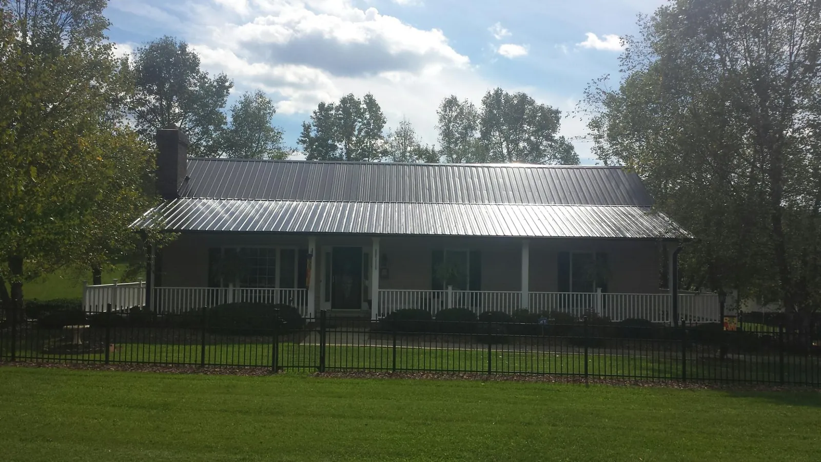 Gray metal roof on a brick ranch with a full width front porch — Gutter Guard Installation work by our crew in Verdon