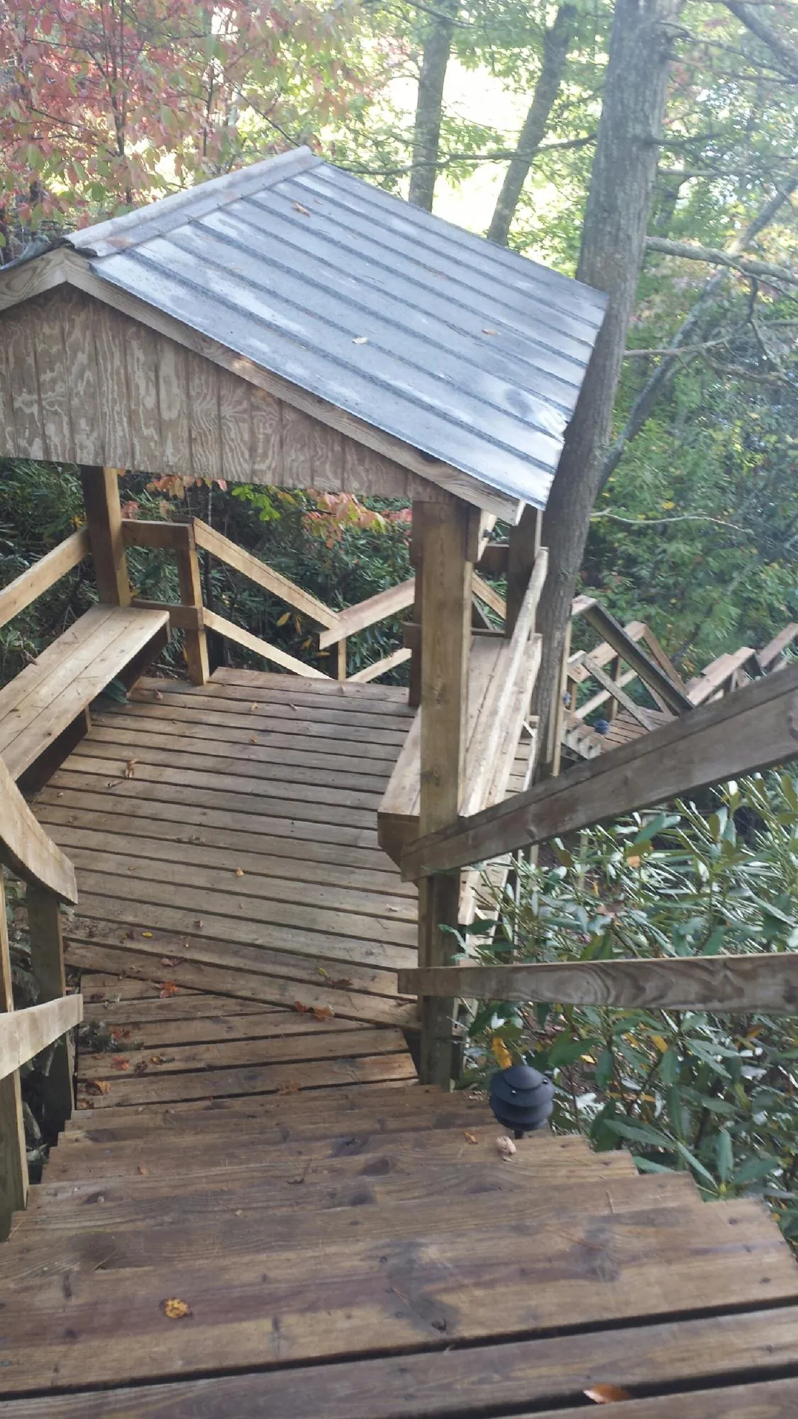 Metal roofed shelter over wooden steps on a wooded walkway — Skylight Repair & Installation work by our crew in Verdon